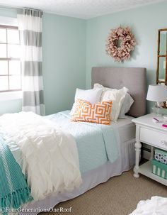 a bedroom with blue walls and white bedding