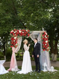 a bride and groom standing under an arch with flowers on it at their wedding ceremony