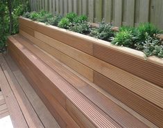 a wooden planter filled with lots of plants on top of a hard wood floor