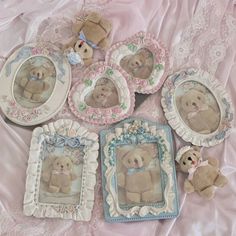 several teddy bears are sitting on a pink blanket with pictures and frames around them, all decorated in pastel colors