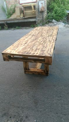 a wooden table sitting on the side of a road