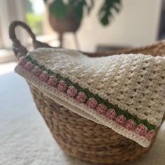 a crocheted dishcloth in a wicker basket on top of a table