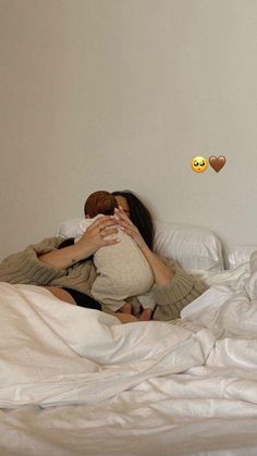 a woman laying in bed with her head on a pillow and two emoticions above her