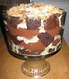 a cake sitting on top of a wooden table covered in frosting and toppings