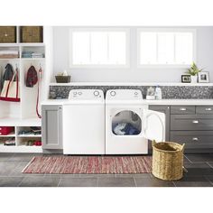 a washer and dryer sitting in a room next to each other on a rug