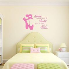 a bed room with a neatly made bed and a wall sticker that says dance with your heart