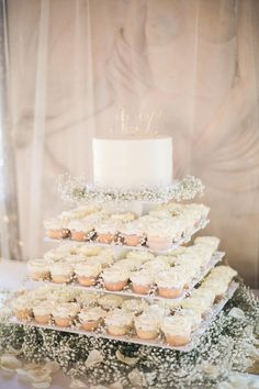 a wedding cake and cupcakes on a table