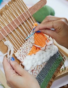 someone is weaving fabric on a loom with their hands and knitting the yarns