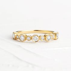 Our sparkling Eleanor ring features five 3mm and six 1.8mm natural VS quality round brilliant cut diamonds bezel set in a 14K Solid Gold mil-grain setting along with a 1.5mm band. This elegant ring is available in 14K Solid Yellow and White Gold. ✨ Features ✨ • Ships Next Day / Fedex 2 Day Service • 14K Solid Gold• Diamond Cut / Round• .65 Ctw / 11 Diamonds Total• Packaged For Gifting • Certificate Of Authenticity Included Classic Stackable Rings With Rose Cut Diamonds, Classic Rose Cut Diamond Stackable Rings, Classic Eternity Band With Rose Cut Diamonds For Promise, Heirloom Style Stackable Round Eternity Band, Heirloom Style Stackable Eternity Band, Heirloom Stackable Round Eternity Band, Classic Stackable Rings With Rose Cut Diamonds For Anniversary, Classic Diamond White Eternity Band With Rose Cut Diamonds, Timeless Eternity Band With Rose Cut Diamonds