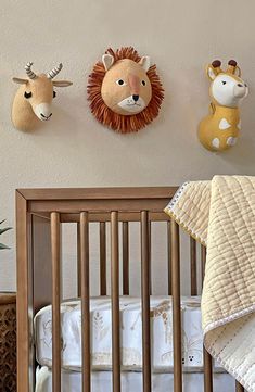 a baby crib with two stuffed animals on the wall above it and another animal head mounted to the wall