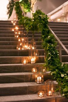 candles are lined up on the stairs to be used as decorations for an outdoor wedding