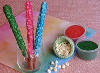 three different colored candles sitting on top of a table next to bowls and spoons