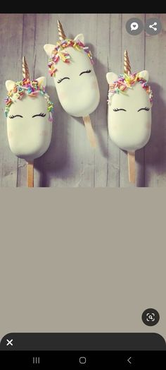 three unicorn lollipops with sprinkles on them sitting next to each other