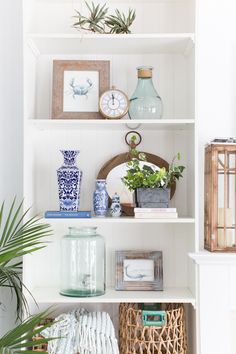 the shelves are filled with vases, books and other decorative items in blue and white