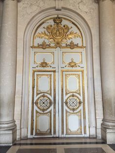 an ornate gold and white door in a building