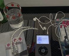 an ipod is sitting on a table next to some books and other items that include headphones