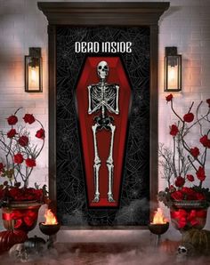 a skeleton standing in front of a red door with roses and candles around it on the floor