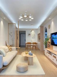 a living room filled with furniture and a flat screen tv on top of a wooden table