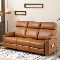 a brown leather reclining sofa sitting on top of a rug