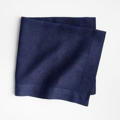 two dark blue linen napkins sitting on top of each other