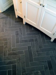 a bathroom with black and white tile flooring next to a counter top on a wooden cabinet