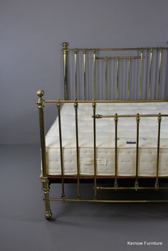 a gold metal bed frame with white mattress