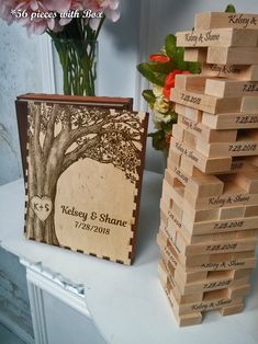 a stack of wooden blocks sitting on top of a table next to a vase with flowers