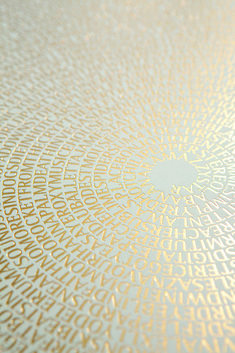 a close up view of an apple logo on a surface with gold and white designs