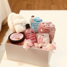 a white box filled with personal care items on top of a wooden table next to a stuffed animal