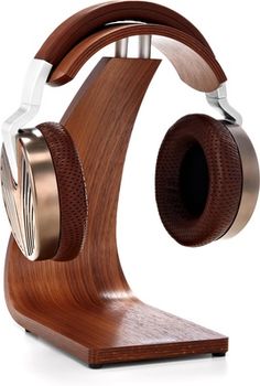 a wooden headphone stand with two headsets attached to the top and one earpiece