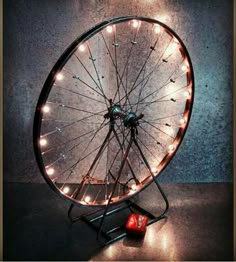 a ferris wheel with lights on it sitting in the middle of a dark room next to a red dice