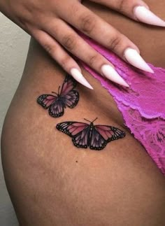 a woman's stomach with two butterflies on it and the bottom half of her belly