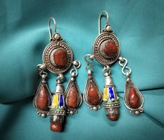 Magnificent kabyle earrings in sterling silver enamelled with blue, green and yellow color, inlaid with two cabochon of real coral. **Height: 7.6 cm. **Width: 3.7 cm. **Material: sterling silver 925, real coral. **Weight: 35.4 grams. **Origin: great Kabyle region 1970s - Algeria. **Shipping: free worldwide by DHL. I am always open to offers for one of my items, so please contact me if you would like to make an offer. Do not hesitate to contact me for any questions. All items advertised for sale Enamel Dangle Jewelry With Matching Earrings, Enamel Dangle Earrings With Matching Jewelry, Ceremonial Enamel Pendant Jewelry, Pierced Dangle Earrings In Enamel, Artisan Red Jewelry With Inlay, Ceremonial Sterling Silver Drop Earrings, Artisan Red Inlay Jewelry, Traditional Enamel Pendant Jewelry, Ornate 925 Stamped Silver Dangle Earrings