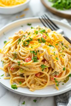 a white plate topped with pasta covered in sauce and garnished with parsley