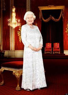 an older woman standing in front of a red and gold room with chandeliers