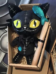 a black cat stuffed animal in a cardboard box