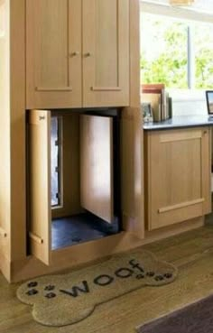 an open dishwasher in the middle of a kitchen with wooden cabinets and drawers