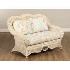 a white wicker chair sitting on top of a hard wood floor