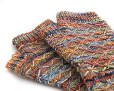 two multicolored knitted scarves sitting on top of each other