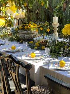 the table is set with lemons and flowers for an outdoor dinner or brunch