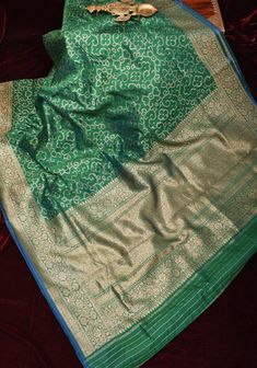 Step into the world of timeless elegance with this Authentic Banarasi Pure Dupion Silk Saree in a majestic Green hue, adorned with a delicate Floral Zari Border.  The Dupion silk is a matt textured drape and features a deep antique tone zari and features a dotted pattern of florals jaal, that showcases the exceptional artistry and expertise of Banarasi weavers. This adds depth and dimension to the saree's design, with each motif meticulously crafted to embody the essence of traditional Indian cr Dupion Silk Saree, Silk Tassels, Trellis Pattern, Dupion Silk, Traditional Indian, Blouse Fabric, Silk Saree, Saree Designs, Silk Sarees