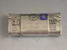 a silver bar with writing on it sitting on a white counter top next to a clock