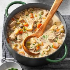 a pot filled with soup and a wooden spoon