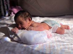 a baby laying on top of a white blanket