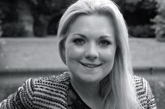 a black and white photo of a woman with long blonde hair smiling at the camera