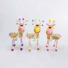 three paper mache reindeers standing next to each other on top of a white surface