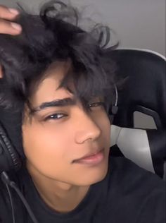 a young man wearing headphones while sitting in a chair