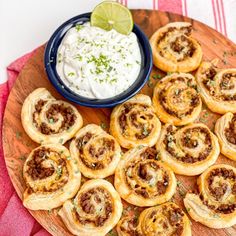 small pastries on a wooden platter with a bowl of sour cream