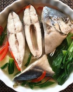 fish and vegetables are in a white bowl