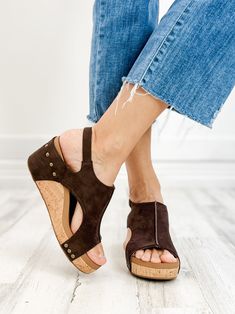 At ELB, we are all huge fans of Corkys, especially the Carley! This shoe is hands down one of the most comfortable you can buy! It is perfect for all seasons, paired with a cute dress, shorts, slacks, or jeans. They are universal! Features: Adjustable sling back closure.E.V.A insole Cork platform wedge.Rubber outsole.Faux Leather Upper2” heel If you wear a 1/2 size, size up to the next whole size. Brown Wedge Heel Sandals For Outings, Brown Wedge Sandals For Spring Outings, Comfortable Brown Wedge Sandals For Spring, Casual Brown Wedge Sandals For Day Out, Blowfish Sneakers, Blowfish Sandals, Blue Denim Top, Wedge Shoe, Long Sleeve Kimono